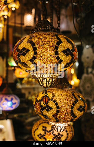 Lot of beautiful glass metal lanterns hang on the background of blurred decorative elements. Lanterns Stock Photo