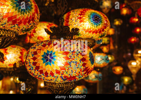 Lot of beautiful glass metal lanterns hang on the background of blurred decorative elements. Lanterns Stock Photo