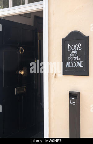 Signpost joke saying Dogs and nice people welcome Stock Photo