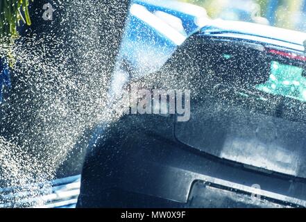 Vehicle Washing in the Car Wash. Automatic Washer Spraying the Car with Active Body Cleaning Foam Stock Photo