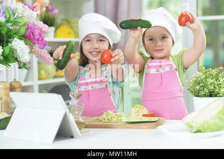 Two adorable little girls in aprons having fun Stock Photo