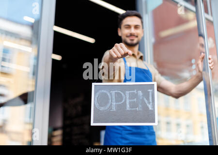 close-up view of smiling male business owner holding open sign Stock Photo