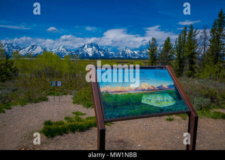 YELLOWSTONE, MONTANA, USA MAY 24, 2018: Close up of informative sign of Teton range and the valley mountains landscape of Grand Teton National Park, Wyoming behind Stock Photo