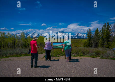 YELLOWSTONE, MONTANA, USA MAY 24, 2018: Unidentified people reading the informative sign and enjoying the landscape of Grand Teton National Park, Wyoming Stock Photo