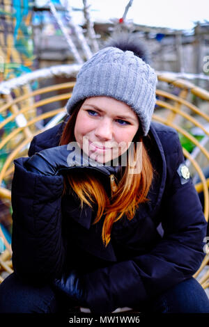 A woman is posing with a hand under the chin at the Nomadic Community Garden off Brick Lane in Shoreditch, East London, England, UK. Stock Photo