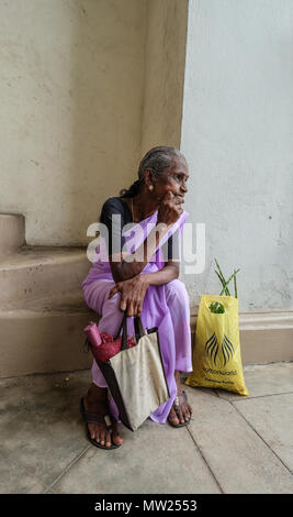 Galle, Sri Lanka - Sep 9, 2015. An old woman sitting and waiting at street market in Galle, Sri Lanka. Stock Photo