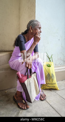 Galle, Sri Lanka - Sep 9, 2015. An old woman sitting and waiting at street market in Galle, Sri Lanka. Stock Photo