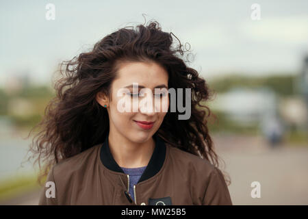 Portrait of attractive young brunette woman with long curly hair Stock Photo