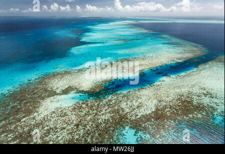 Colorful aerial view of large expanse of coral reefs and white sandbars stretching to the horizon in a zig zag pattern Stock Photo