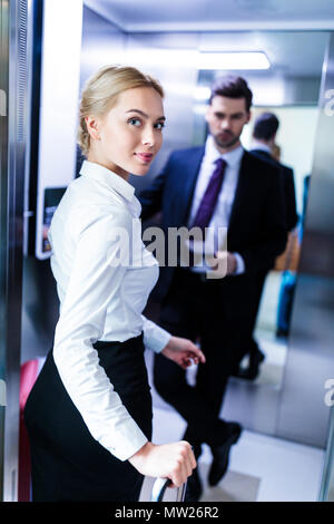 businessman and businesswoman entering elevator in hotel Stock Photo