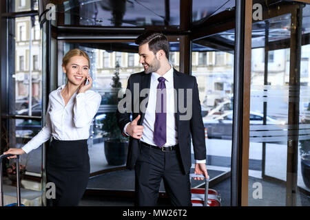 businesswoman entering hotel and talking by smartphone Stock Photo