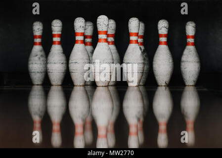 grungy bowling pins in gate with reflection in polished floor Stock Photo