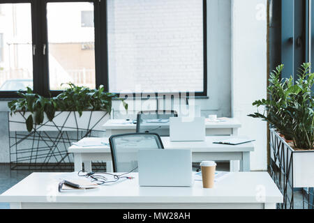 headsets and laptops on tables in light empty office Stock Photo