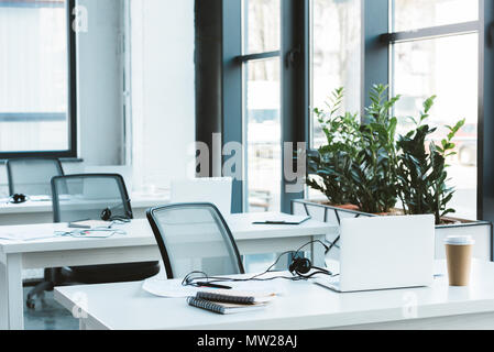 headsets and laptops on tables in modern office Stock Photo