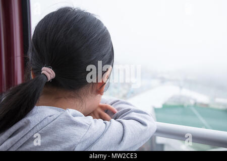 Asian chinese little girl riding cable car and enjoying the view Stock Photo