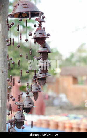 Beautiful garden ornaments—bells, beads, birds—made of clay, suspended from a pole, on sale at Shilparamam arts & crafts village in Hyderabad, India. Stock Photo