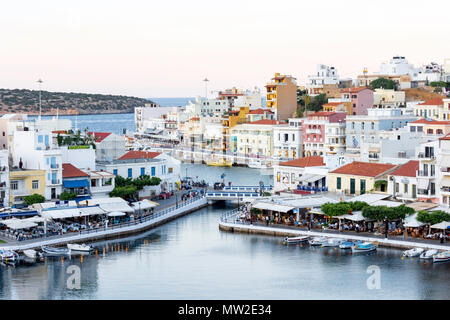 View of town and harbour at dusk, Agios Nikolaos, Lasithi Region, Crete (Kriti), Greece Stock Photo