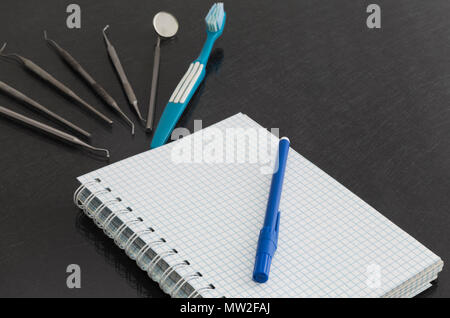 Dental tools, equipment and dental chart on gray background. Stock Photo