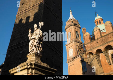 Italy, Emilia-Romagna, Bologna: statue in front of one of the towers of Bologna. In the background, the Church of Santi Bartolomeo e Gaetano Stock Photo