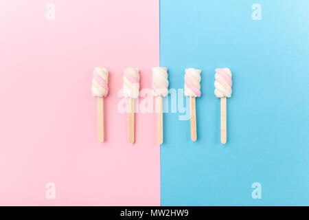 Different pastel color marshmallows on sticks on  pink blue pastel background with copy space. Top View. Conceptual Food Trend Flat Lay Stock Photo