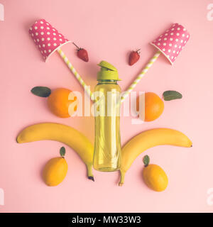 Tropical creative concept made of fruits, paper cups and bottle isolated on pastel pink background. Stock Photo