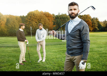 Group of friends walking on the golf course Stock Photo