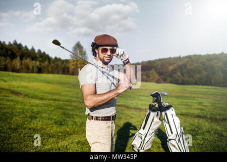 Golf player holding a golf club in golf course Stock Photo