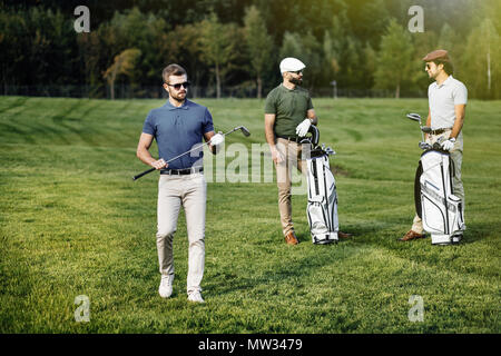 Group of friends walking on the golf course Stock Photo