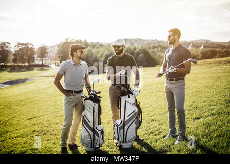 Group of friends walking on the golf course Stock Photo