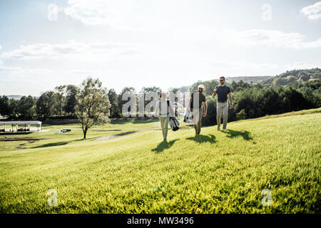 Group of friends walking on the golf course Stock Photo