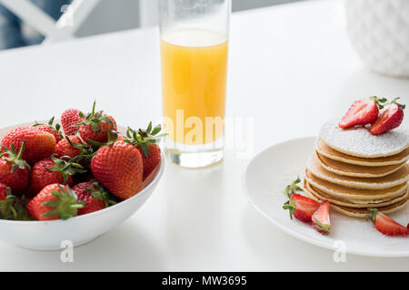 close-up shot of tasty pancakes with strawberries and orange juice Stock Photo