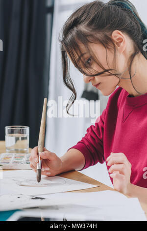 Female designer drawing with large brush Stock Photo