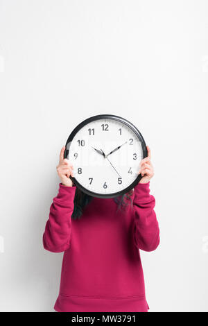 Girl holding clock over her face isolated on white Stock Photo