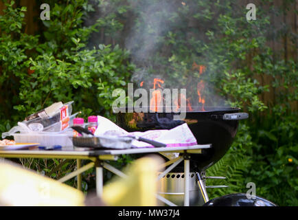 A Flaming barbecue alight on fat from food. Stock Photo