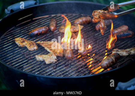 Flame grilling meat on a barbecue Stock Photo