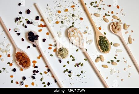 Concept of wooden spoons full of seeds and cereals on white background, flat lay, top view Stock Photo