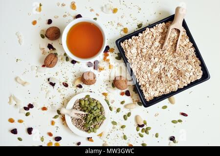 Concept of bowls full of seeds, cereals and honey on white background, top table Stock Photo