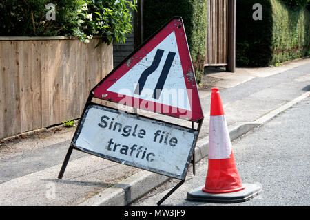 UK road sign. Road narrows from left single file traffic Stock Photo