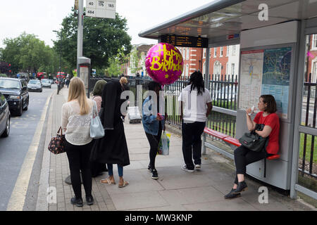A young woman carries an oversized Happy Birthday balloon for a friend in Camberwell, on 30th May 2018, in London, England. Stock Photo