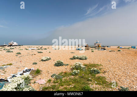 Fishing boats and fishing industry items on the shingle beach at Dungeness, Kent, UK. Stock Photo