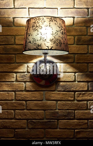 Brick wall with a glowing beautiful lamp. Copy of space. Stock Photo