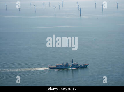 Aerial photo of Royal Navy Frigate passing wind turbines Liverpool Bay Stock Photo