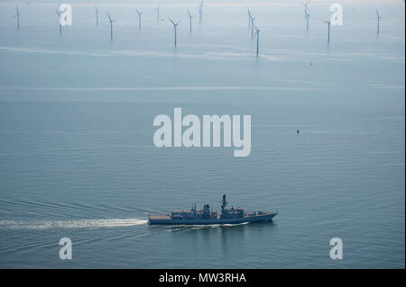 Aerial photo of Royal Navy Frigate passing wind turbines Liverpool Bay Stock Photo