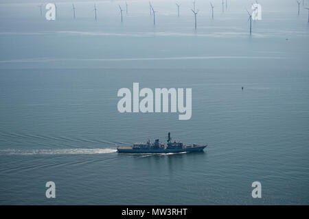 Aerial photo of Royal Navy Frigate passing wind turbines Liverpool Bay Stock Photo