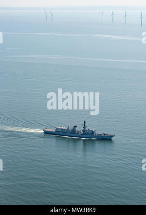 Aerial photo of Royal Navy Frigate passing wind turbines Liverpool Bay Stock Photo