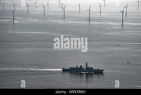 Aerial photo of Royal Navy Frigate passing wind turbines Liverpool Bay Stock Photo