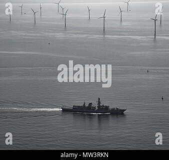 Aerial photo of Royal Navy Frigate passing wind turbines Liverpool Bay Stock Photo