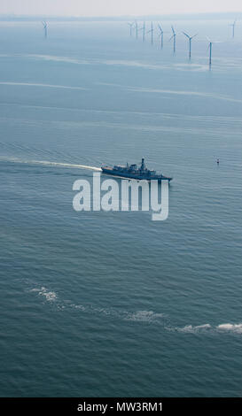 Aerial photo of Royal Navy Frigate passing wind turbines Liverpool Bay Stock Photo