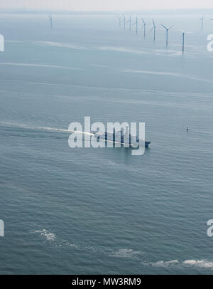 Aerial photo of Royal Navy Frigate passing wind turbines Liverpool Bay Stock Photo