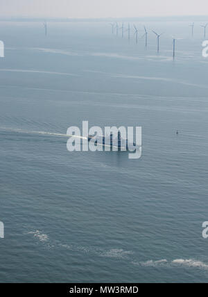 Aerial photo of Royal Navy Frigate passing wind turbines Liverpool Bay Stock Photo